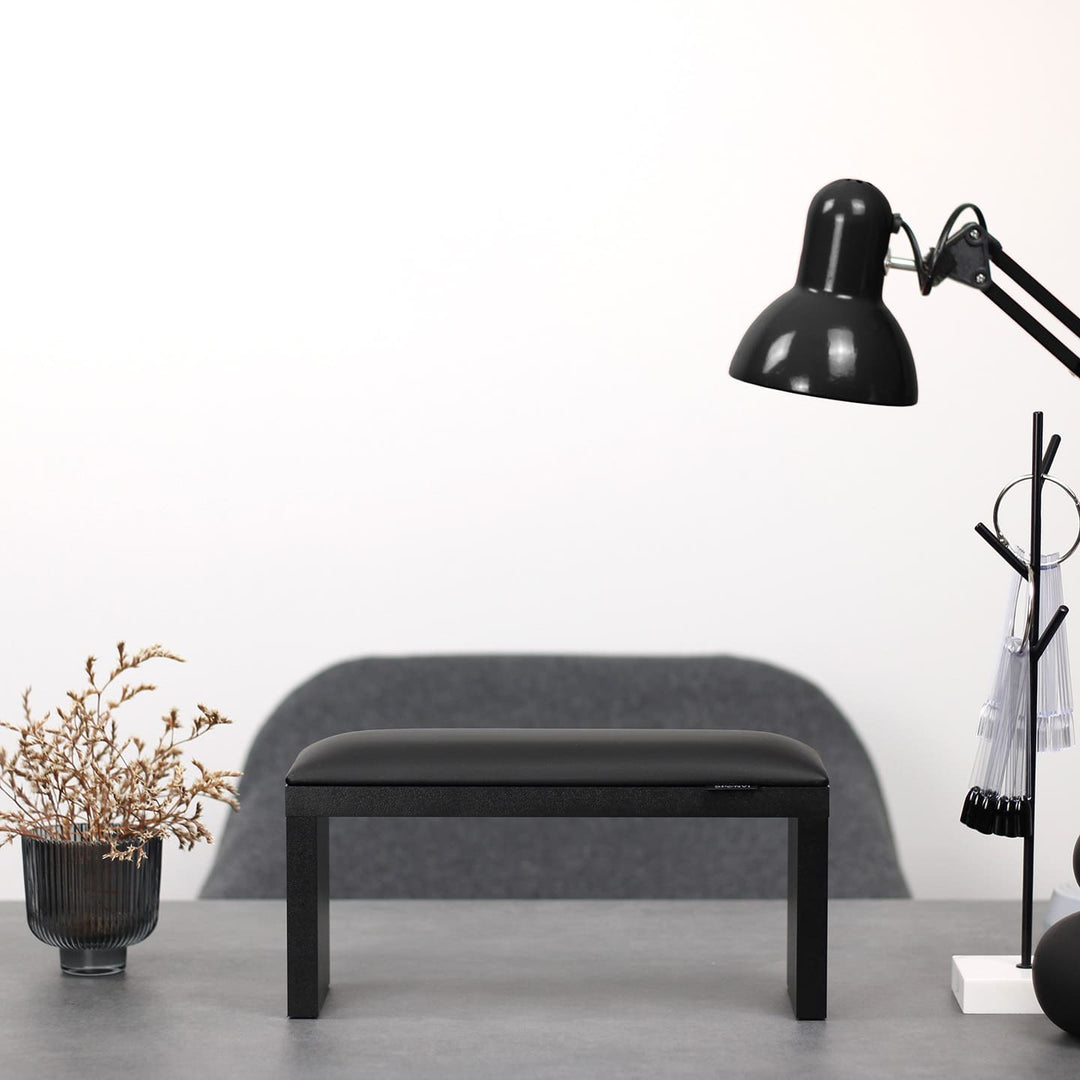 Podpórka do manicure SPENVI Classic czarna z czarnymi drewnianymi nogami ustawiona na biurku w salonie stylizacji paznokci. #kolor_black