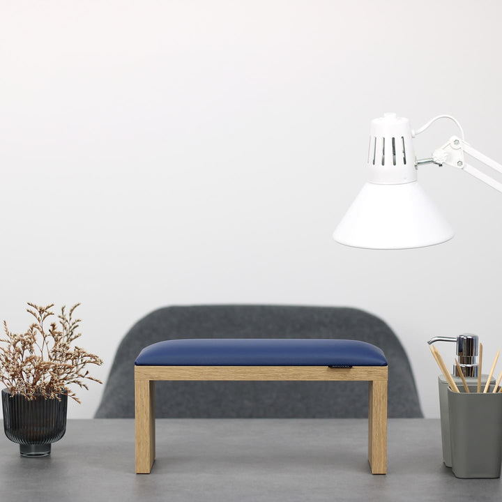 Podpórka do manicure SPENVI Classic niebieska z drewnianymi nogami ustawiona na biurku w salonie stylizacji paznokci. #kolor_blue