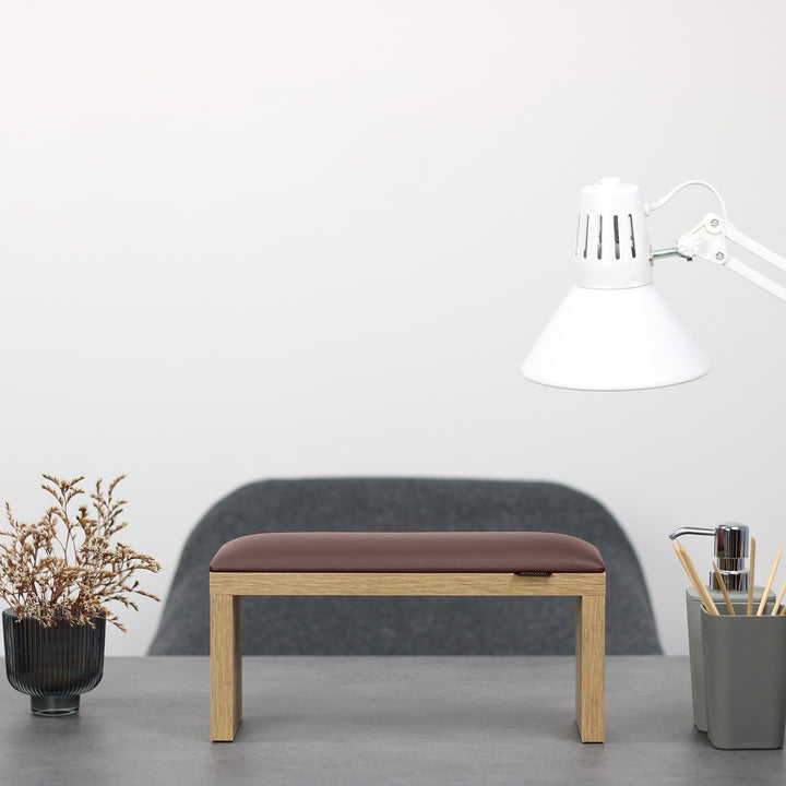 Podpórka do manicure SPENVI Classic czekoladowa z drewnianymi nogami ustawiona na biurku w salonie stylizacji paznokci. #kolor_chocolate