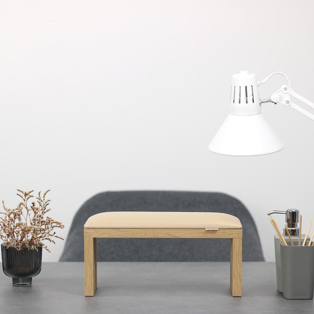 Podpórka do manicure SPENVI Classic kremowa z drewnianymi nogami ustawiona na biurku w salonie stylizacji paznokci. #kolor_coffee-milk