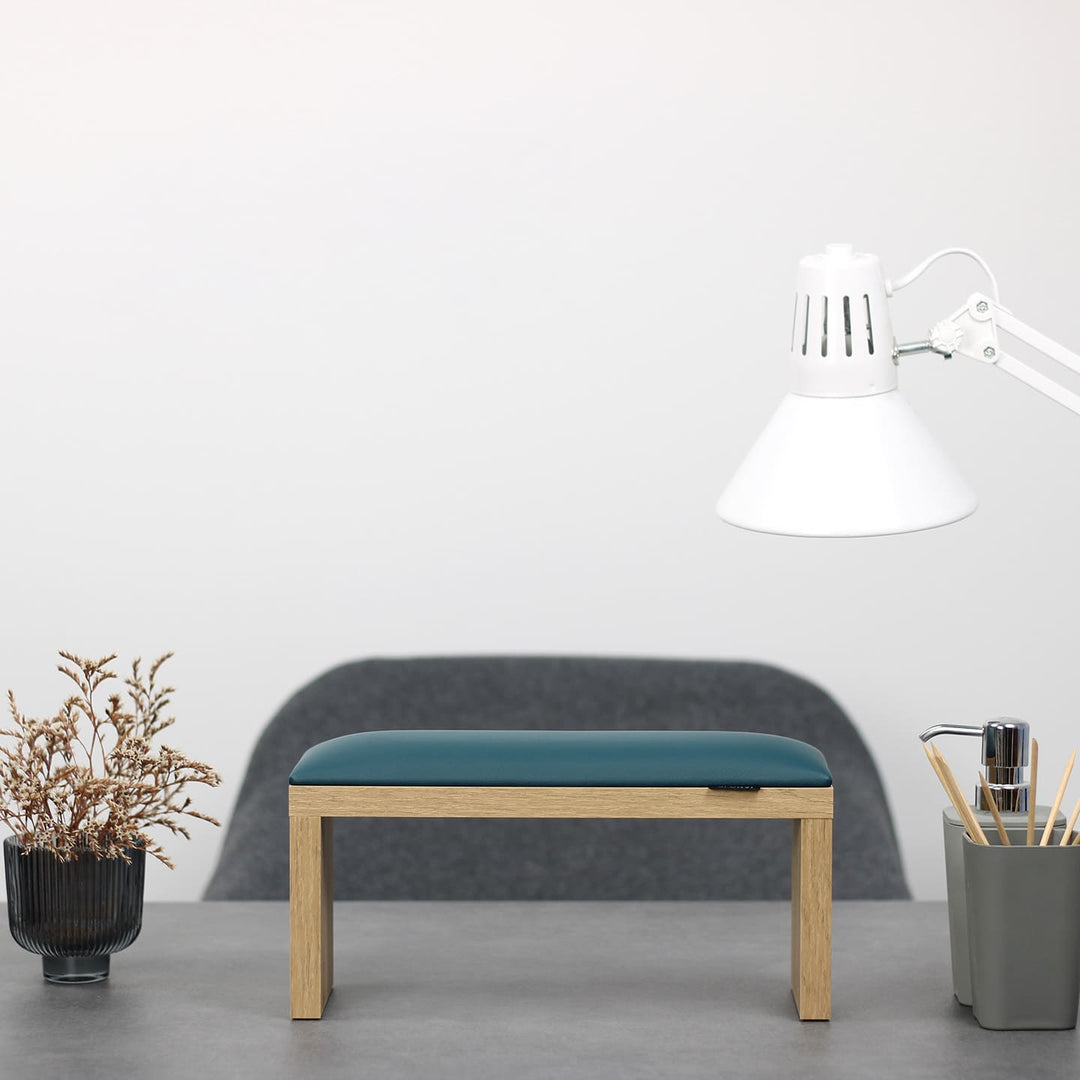 Podpórka do manicure SPENVI Classic zielona z drewnianymi nogami ustawiona na biurku w salonie stylizacji paznokci. #kolor_dark-green