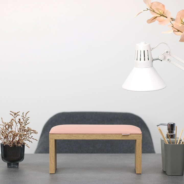 Podpórka do manicure SPENVI Classic różowa z drewnianymi nogami ustawiona na biurku w salonie stylizacji paznokci. #kolor_light-pink