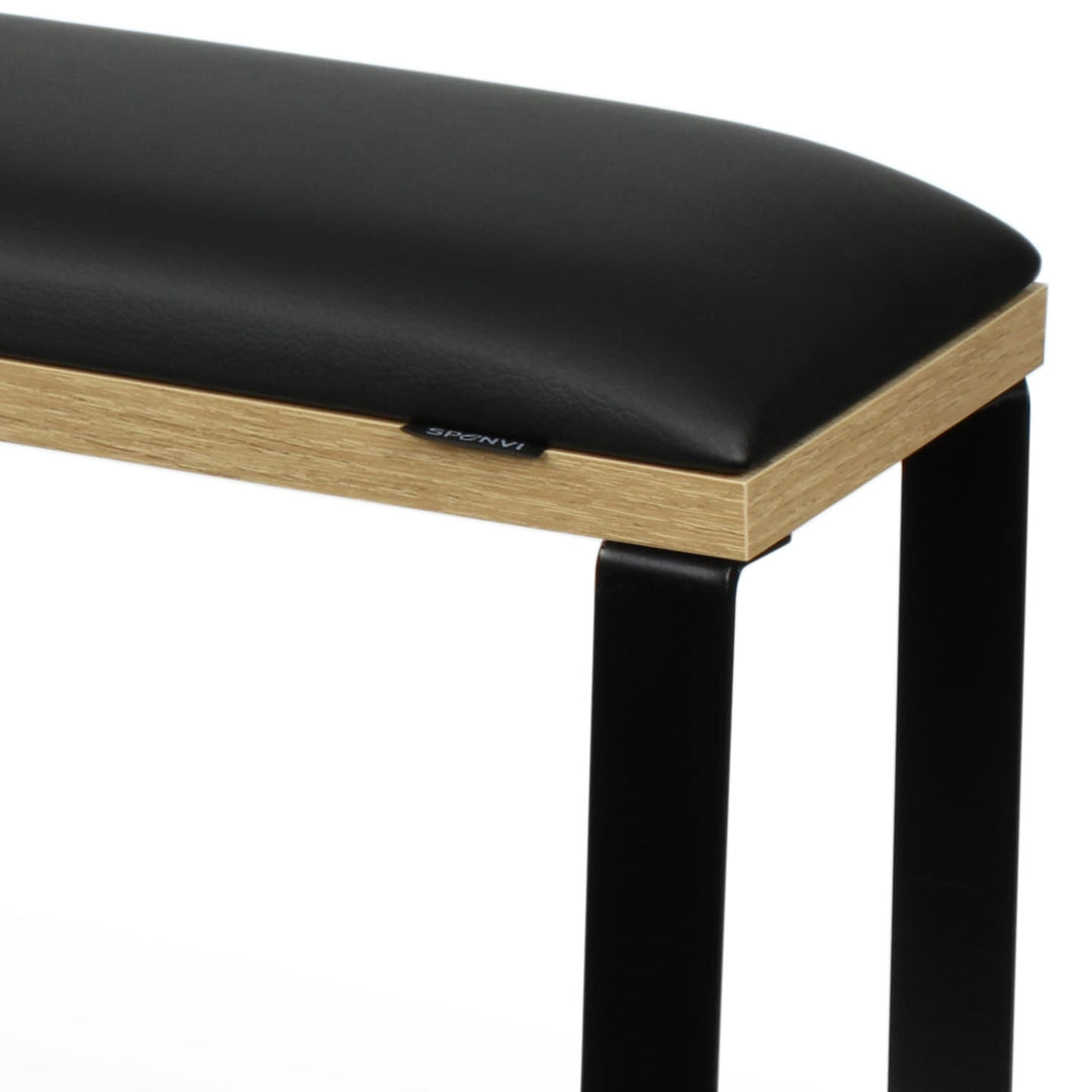 Zbliżenie podpórki do pedicure SPENVI Loft Black z czarną poduszką z ekoskóry, podstawą w wykończeniu naturalnego drewna i stabilną metalową konstrukcją. #kolor_black